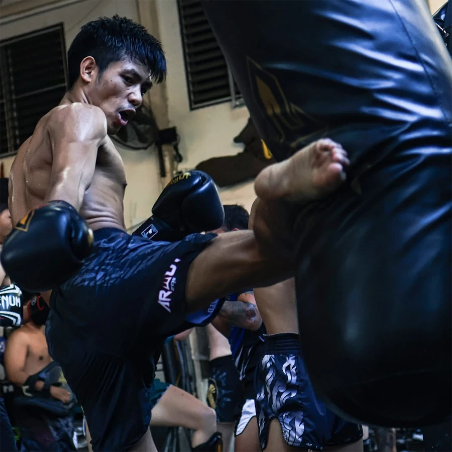 Person practicing Muay Thai with a focus on kicking technique.