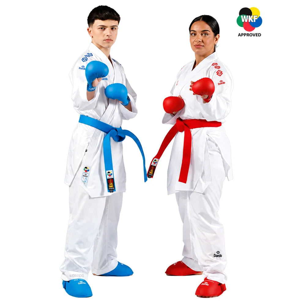 Two children modeling white karate uniforms with colored belts and gloves, standing against a white background. One wears a blue belt and blue gloves, and the other wears a red belt and red gloves.