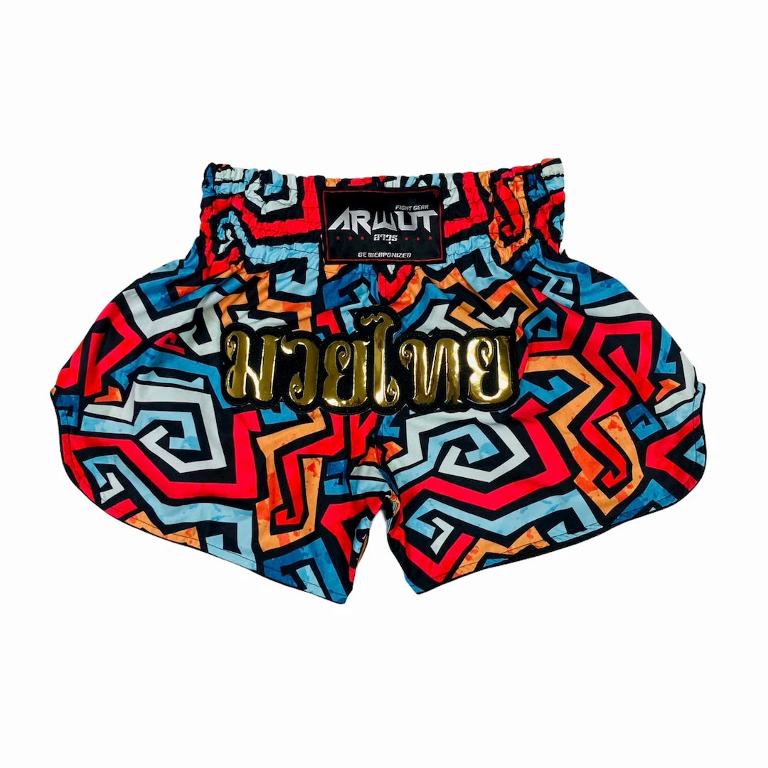 Colorful patterned Muay Thai shorts with a brand label on a white background