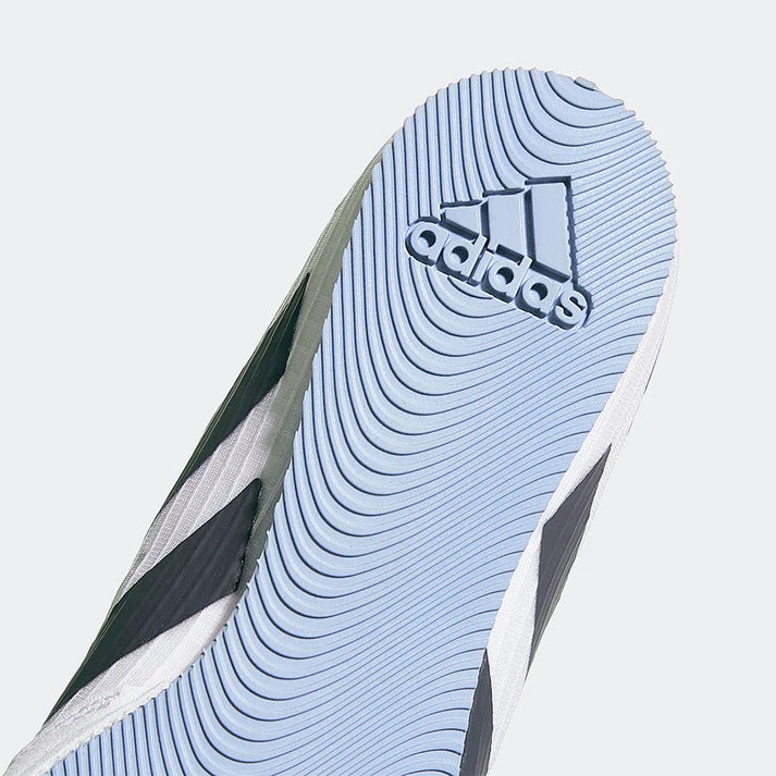 Close-up of an Adidas shoe sole with brand logo on a light gray background