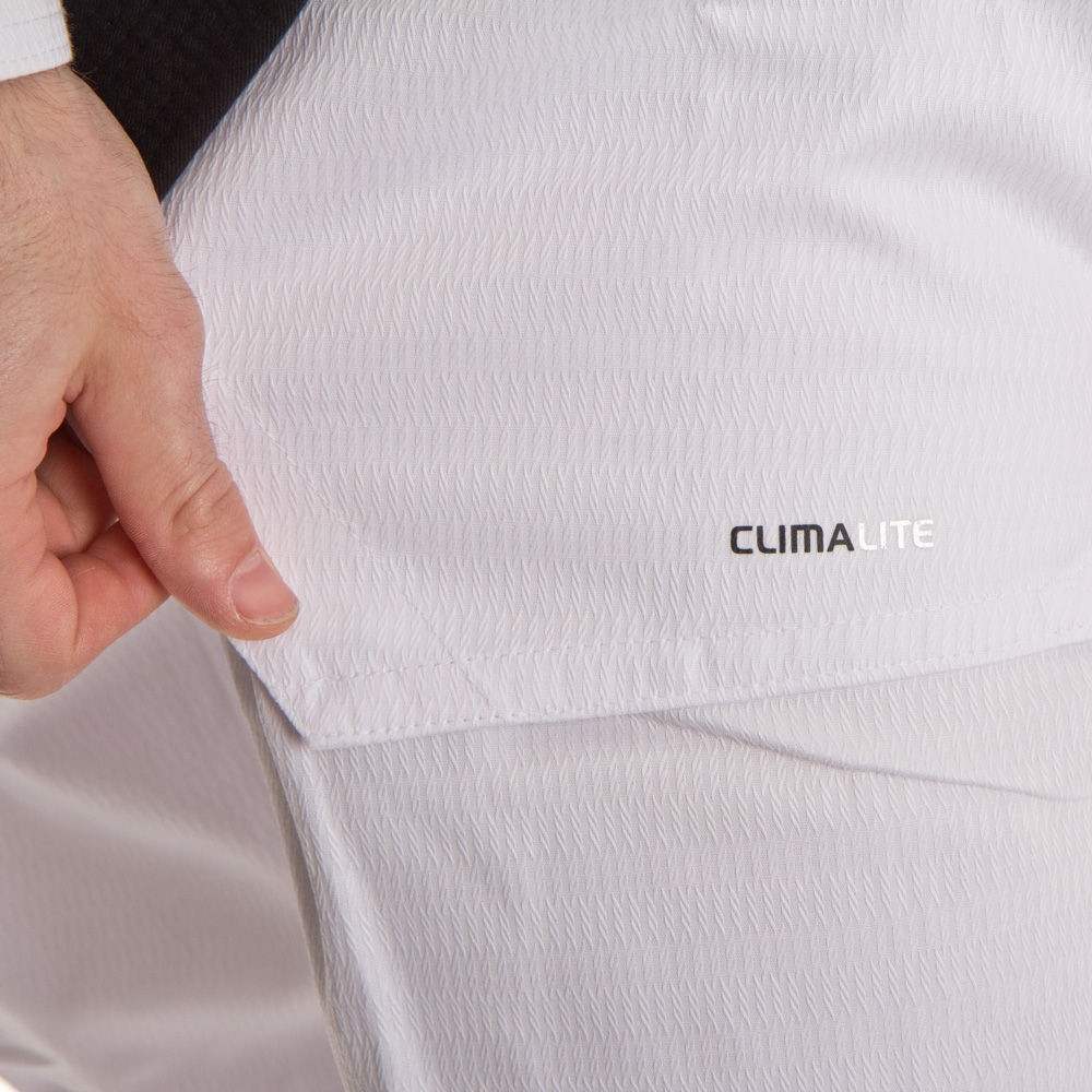 Close-up of a white garment with 'CLIMALITE' branding, held by a hand.
