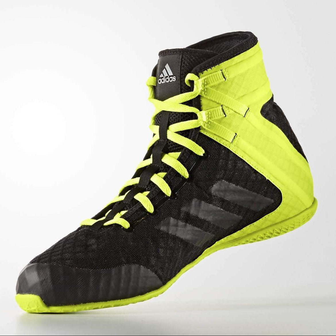 Black and yellow Adidas boxing shoe on a light gray background