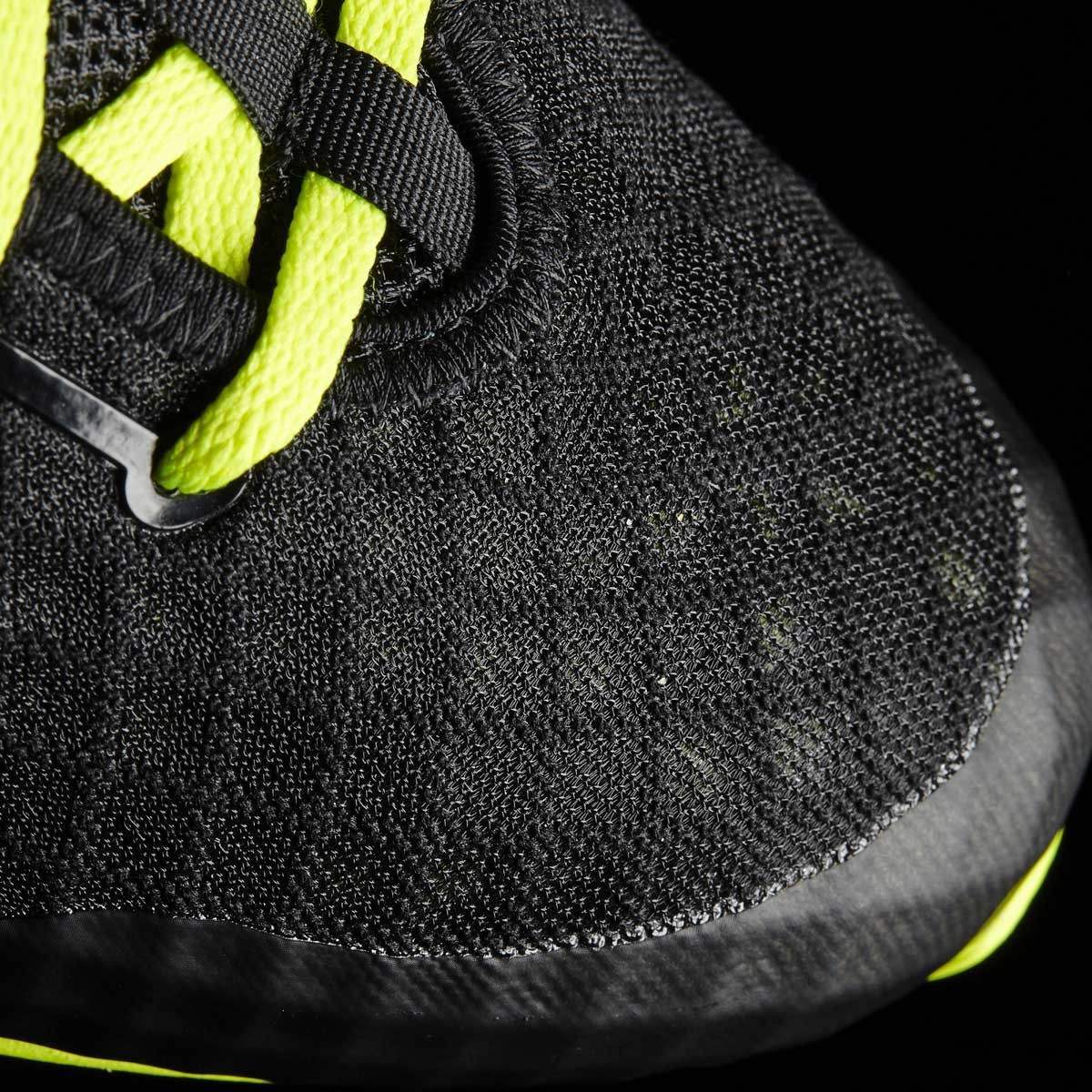 Close-up of a black sneaker with neon yellow accents on a black background