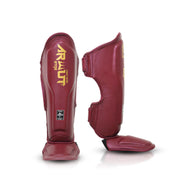 Maroon shin guards with gold Arwut branding on a white background