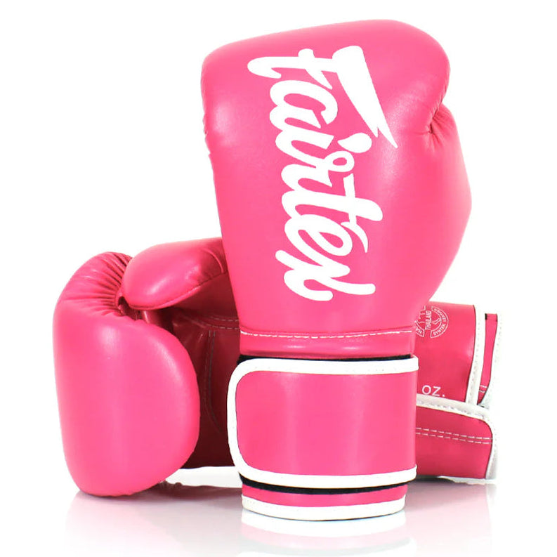 Pink boxing gloves with 'fairtex' branding on a white background
