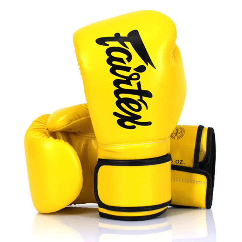 Yellow boxing gloves with 'fairtex' branding on a white background