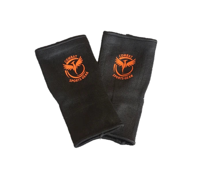 Pair of black ankle guards with orange logo on a white background