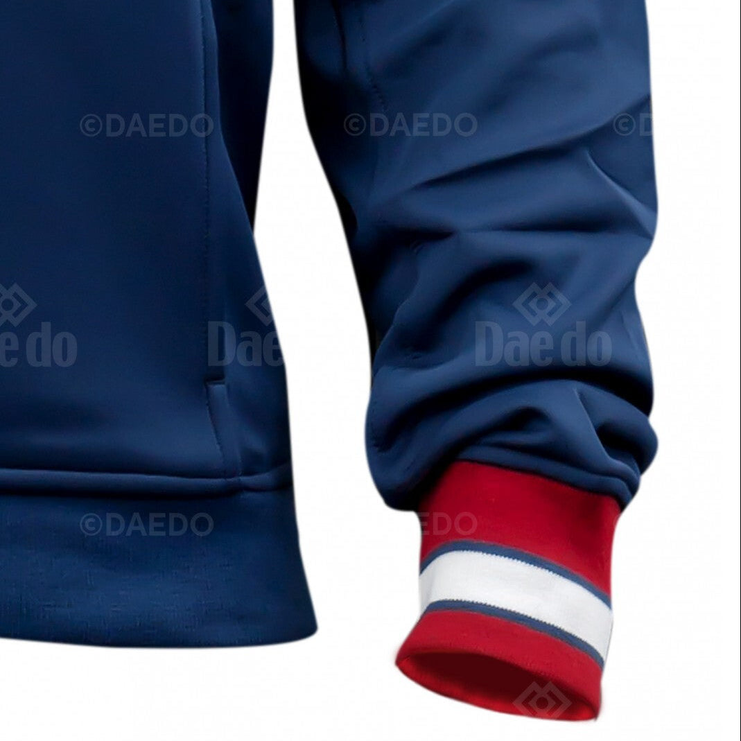 Close-up of a blue jacket with red and white cuffs on a white background, featuring the Daedo brand.