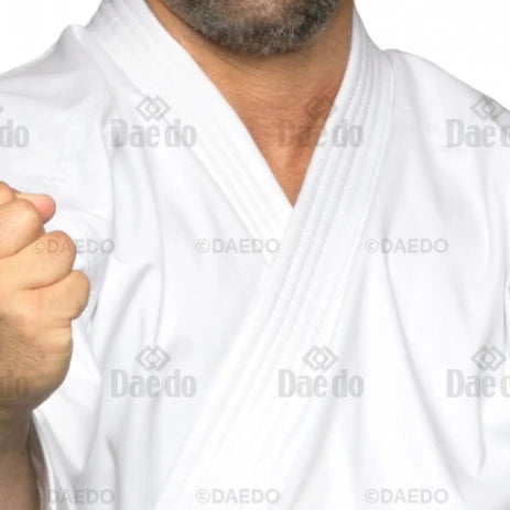 Person wearing a white martial arts uniform with 'Daedo' branding.