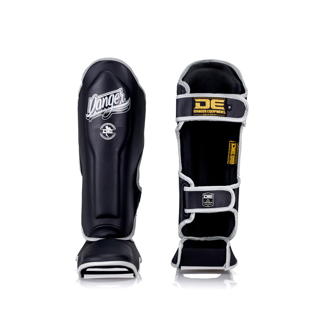 Black shin guards with 'Danger Equipment' branding on a white background