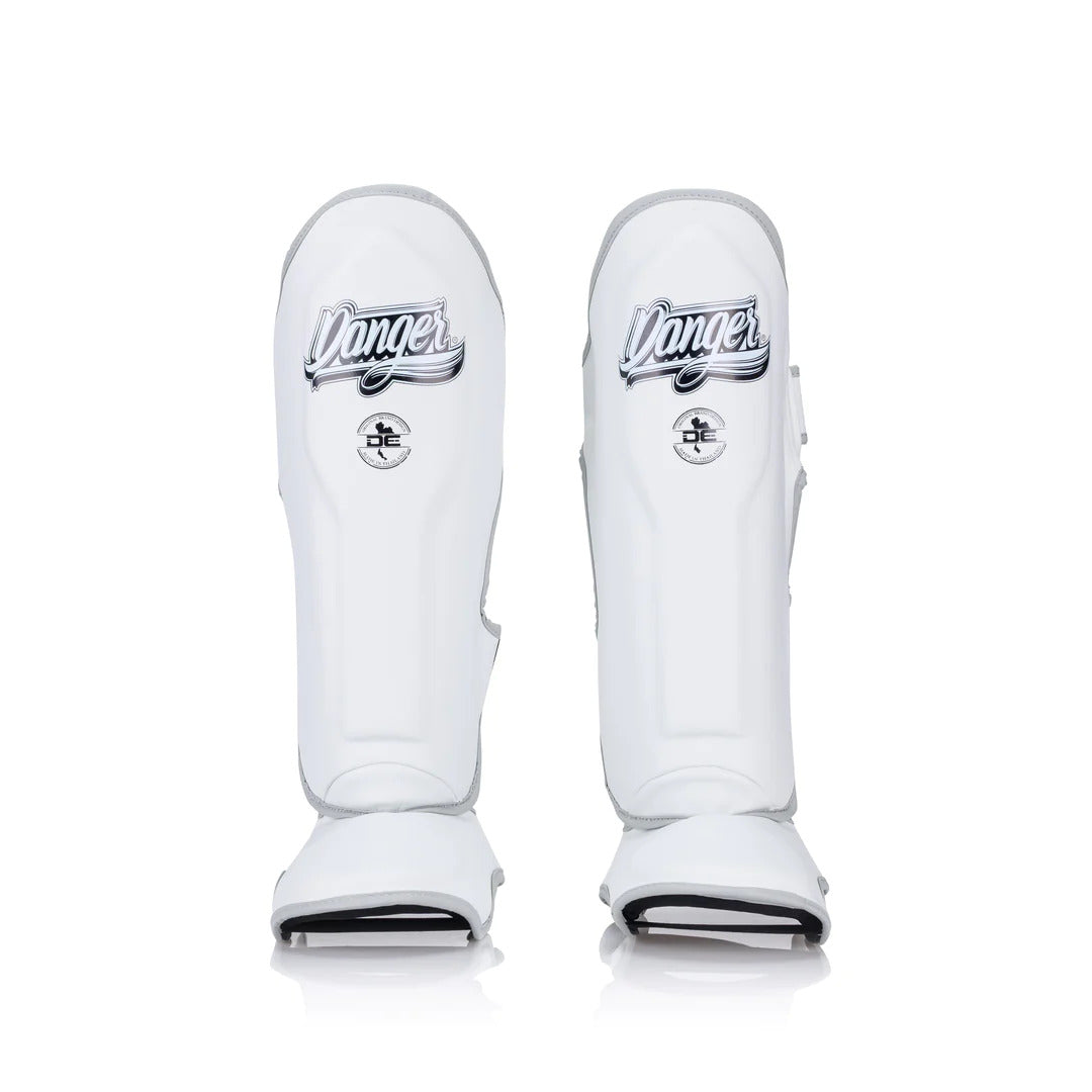 Pair of white shin guards with 'Danger' branding on a white background