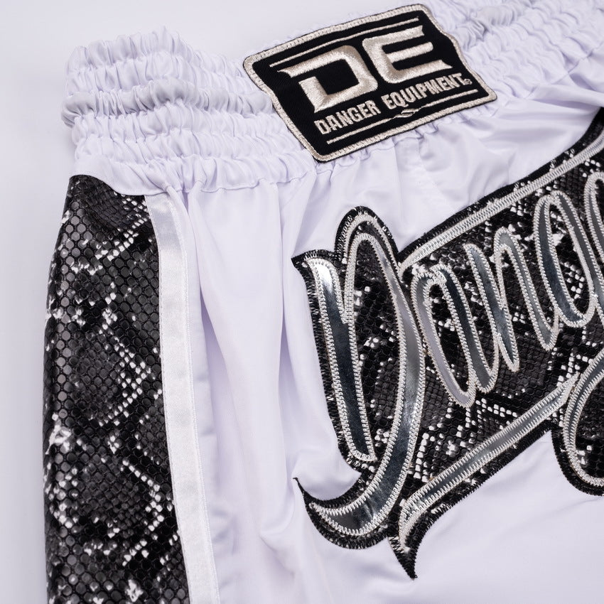 White shorts with black sequin text and 'DE' logo on a white background