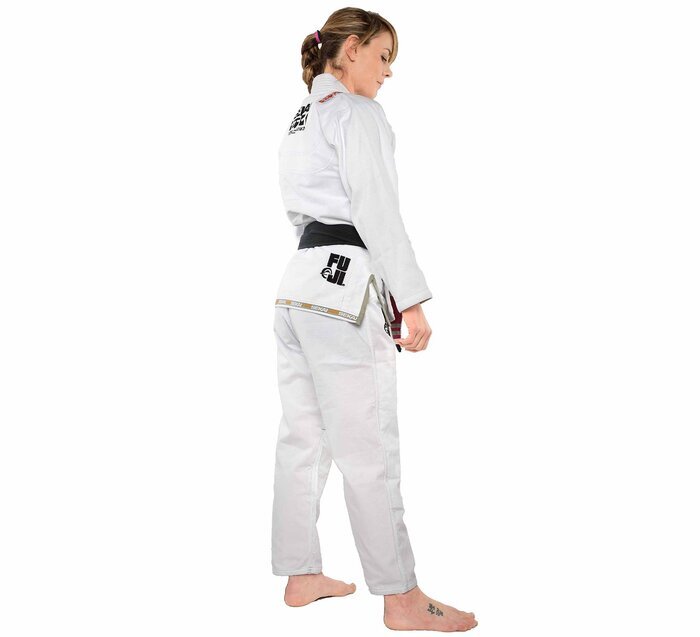 Female wearing a white martial arts uniform with a black belt on a white background