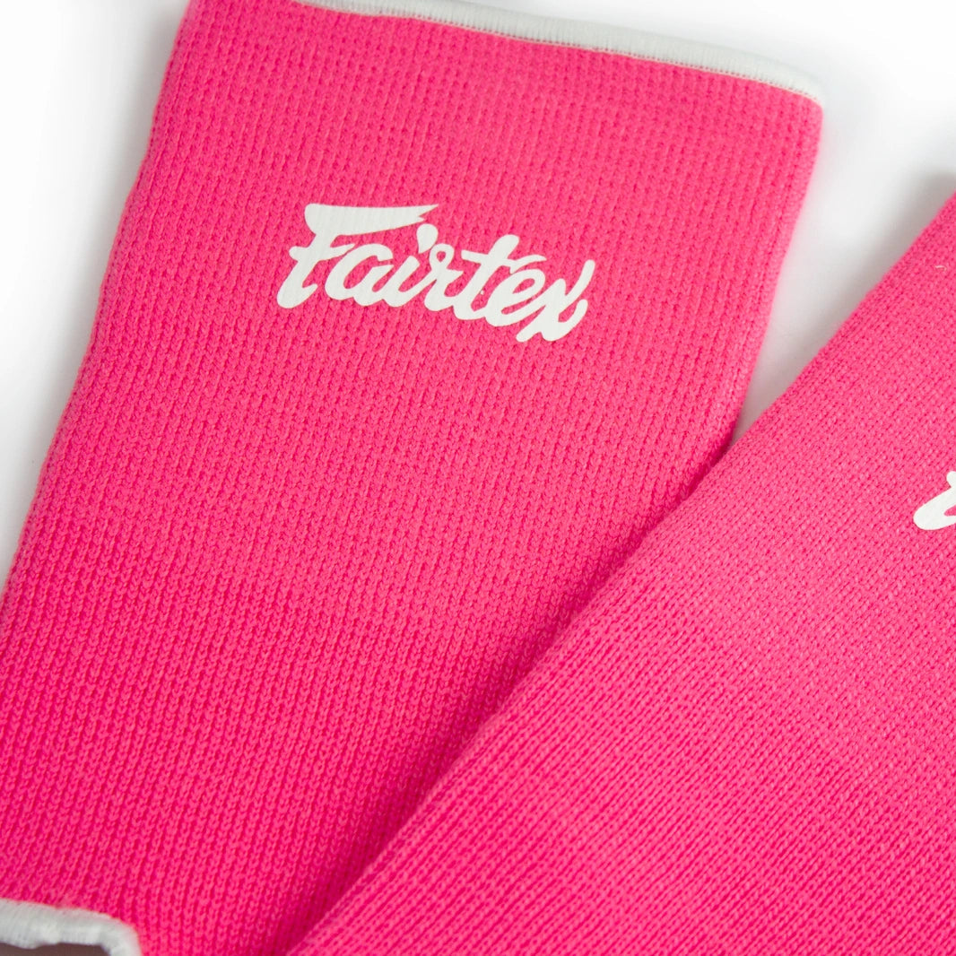 Two pink Fairtex anklets on a white background