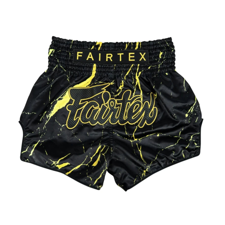 Black and yellow Fairtex thai shorts on a white background