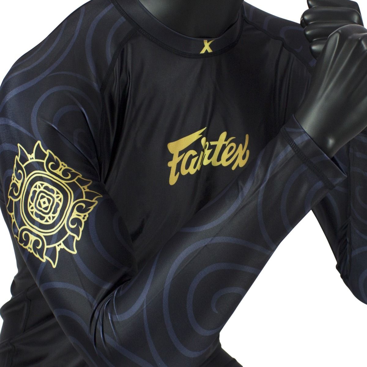 Black rashguard with gold patterns and 'Fairtex' branding on a white background