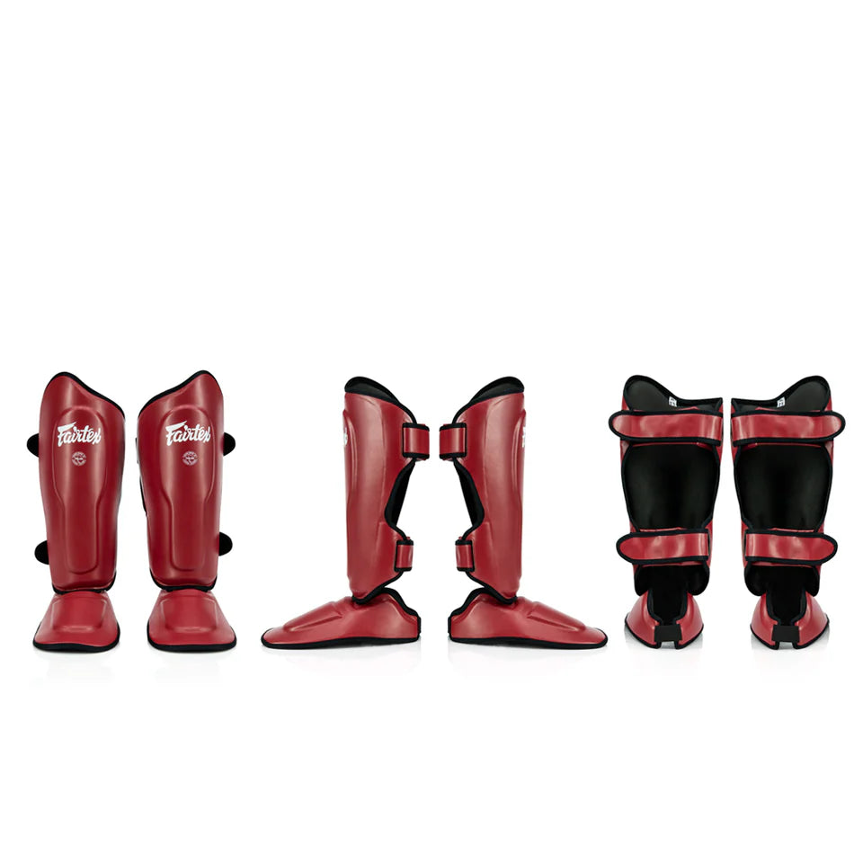 Set of red and black Fairtex shin guards on a white background