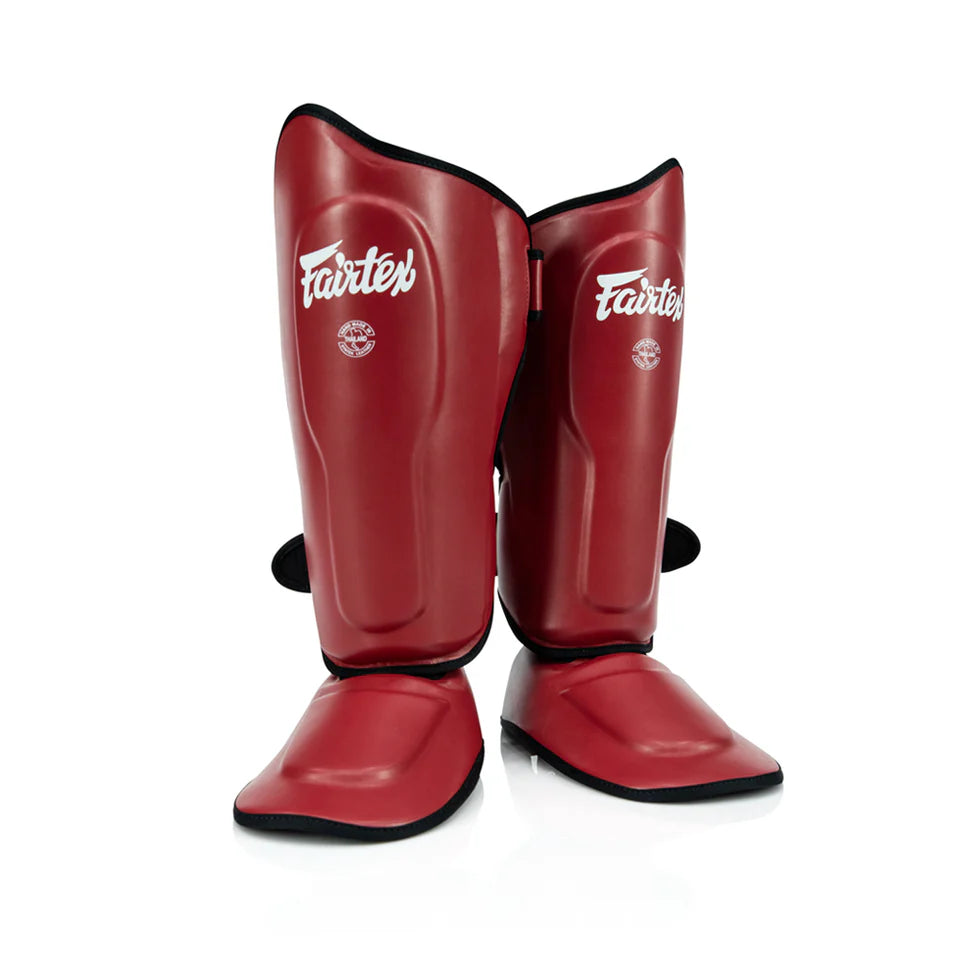 Red shin guards with 'Fairtex' branding on a white background