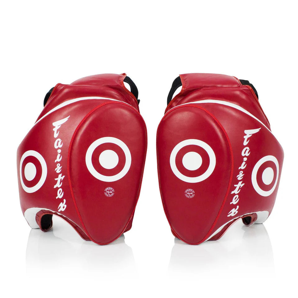 Pair of red Muay Thai thigh pads with white circular designs on a white background