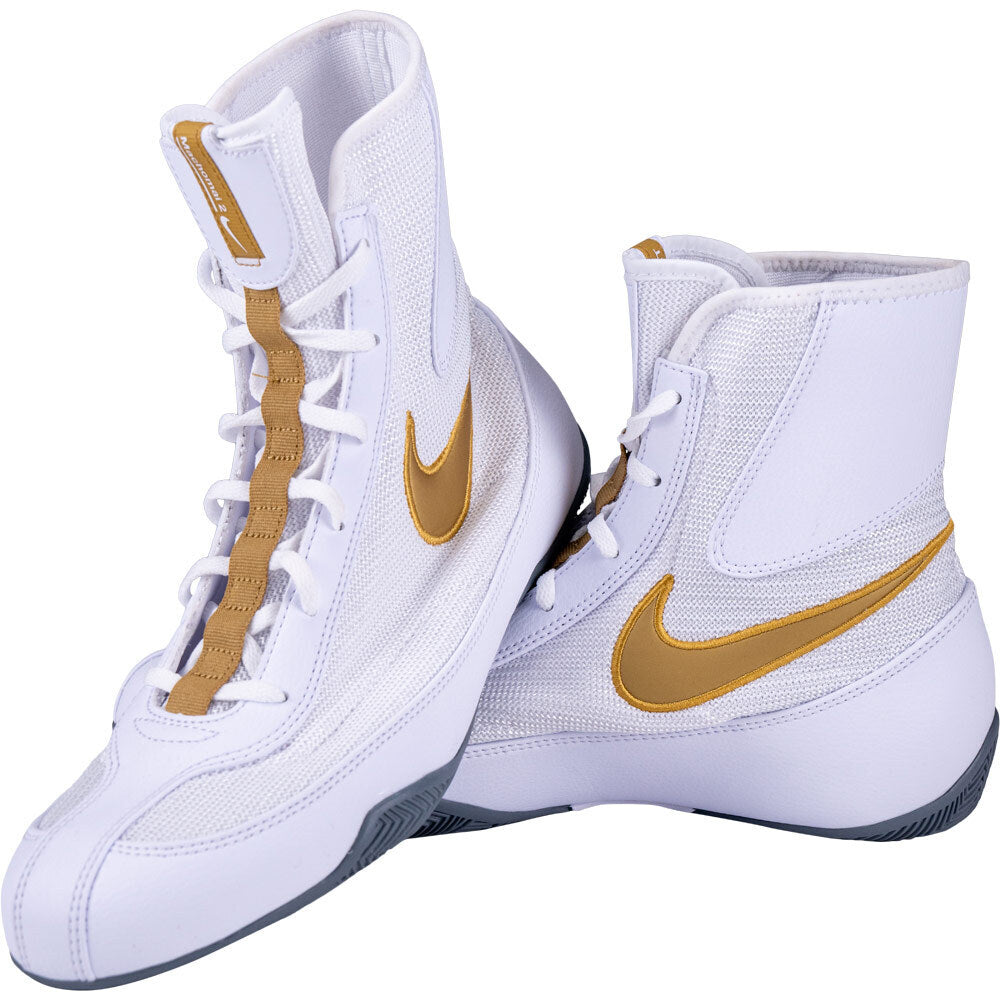 White high-top boxing sneakers with gold Nike swoosh logo on a white background
