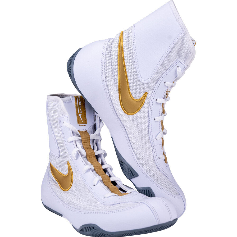 White high-top Nike boxing shoes with gold accents on a white background