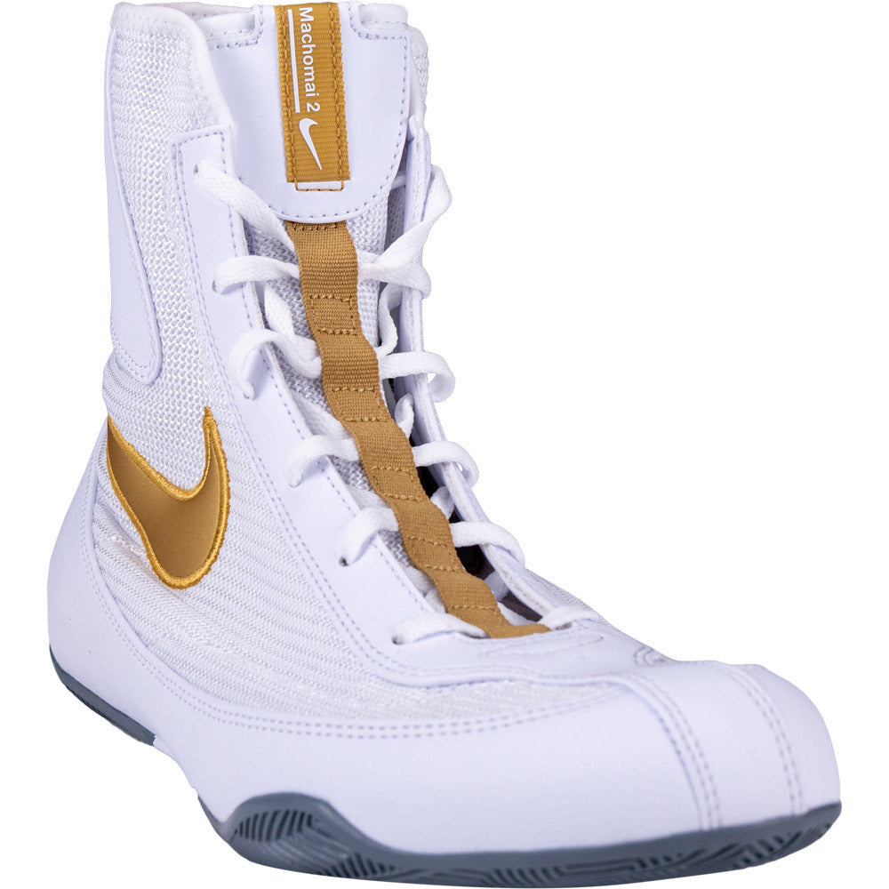 White Nike boxing shoe with gold accents on a white background