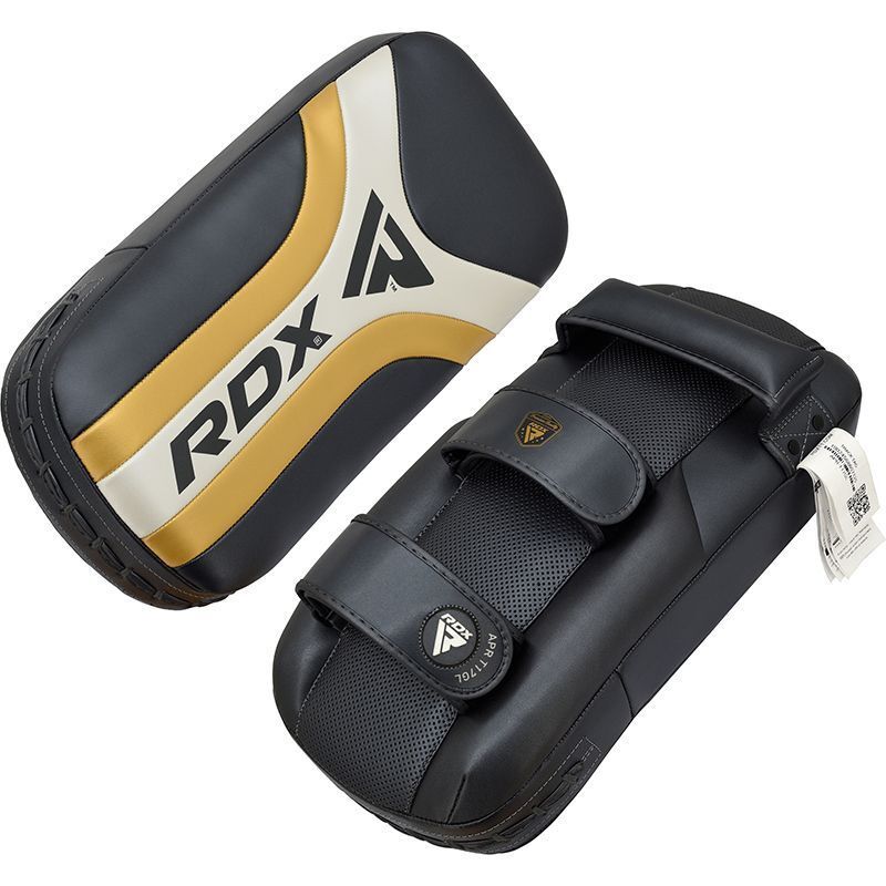 Black and gold RDX Muay Thai pad with a black pull back straps on a white background