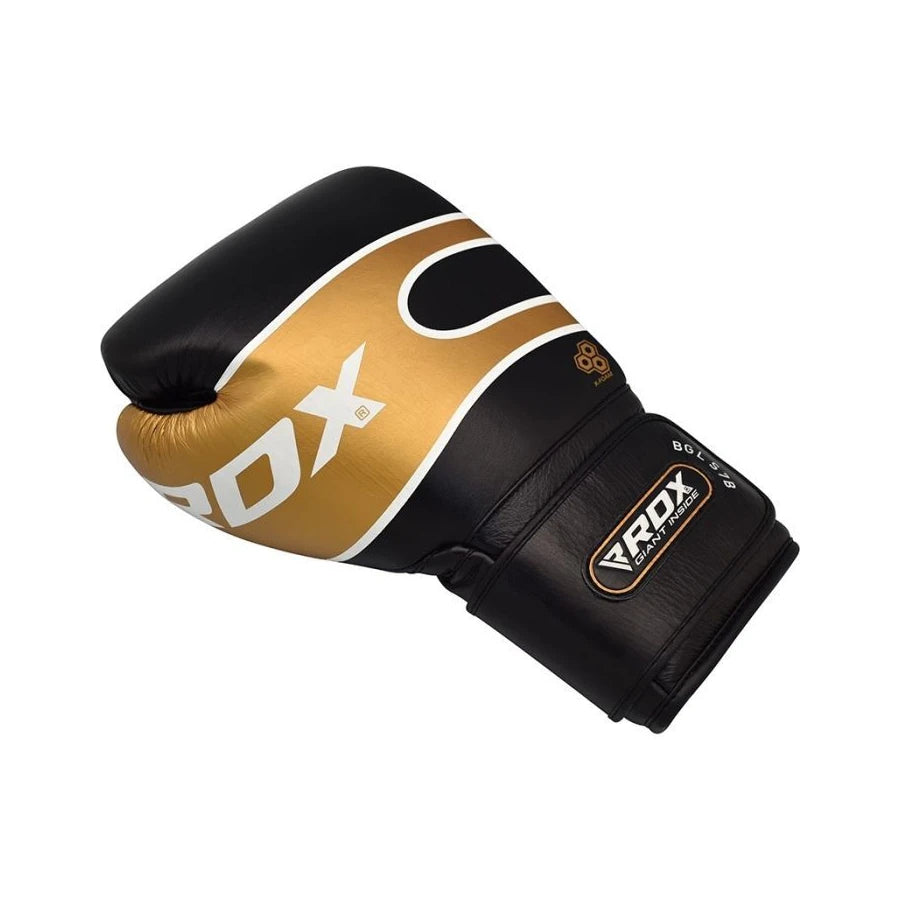 Black and gold boxing glove with RDX branding on a white background