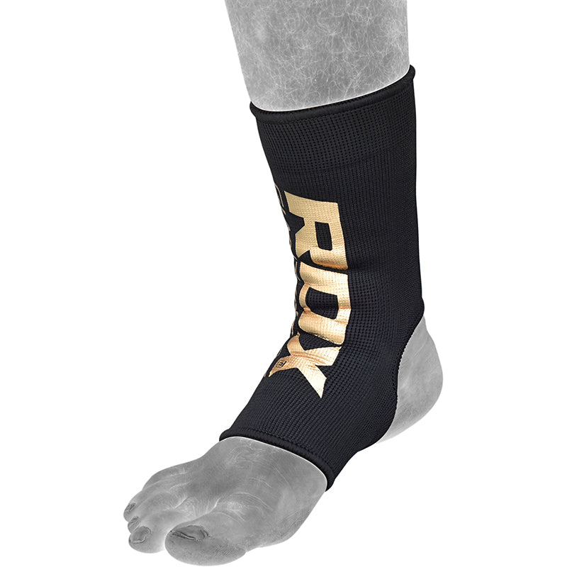 Black ankle supports with gold RDX logo worn by a person on a white background