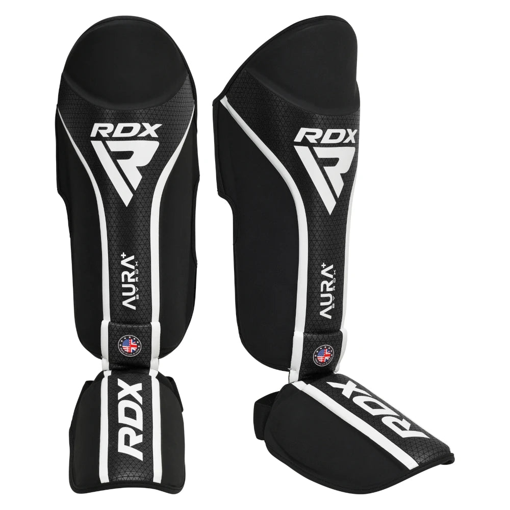 Black RDX shin guards with white accents on a white background