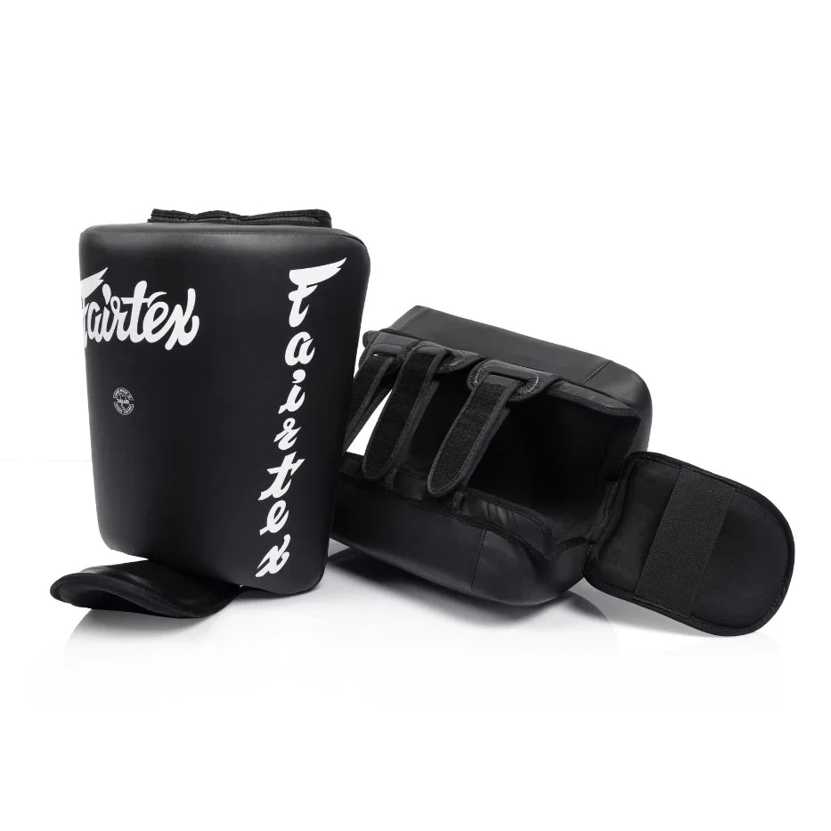 Pair of black shin and calf pads with 'Fairtex' branding on a white background