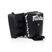 Black Muay Thai calf protectors with 'Fairtex' branding on a white background