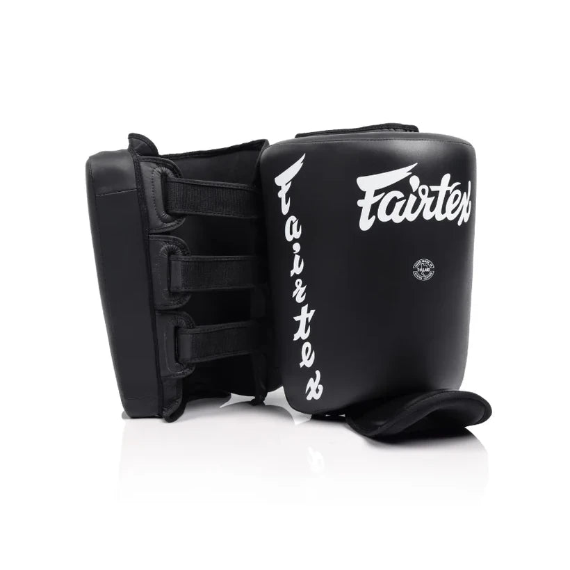 Black Muay Thai calf protectors with 'Fairtex' branding on a white background