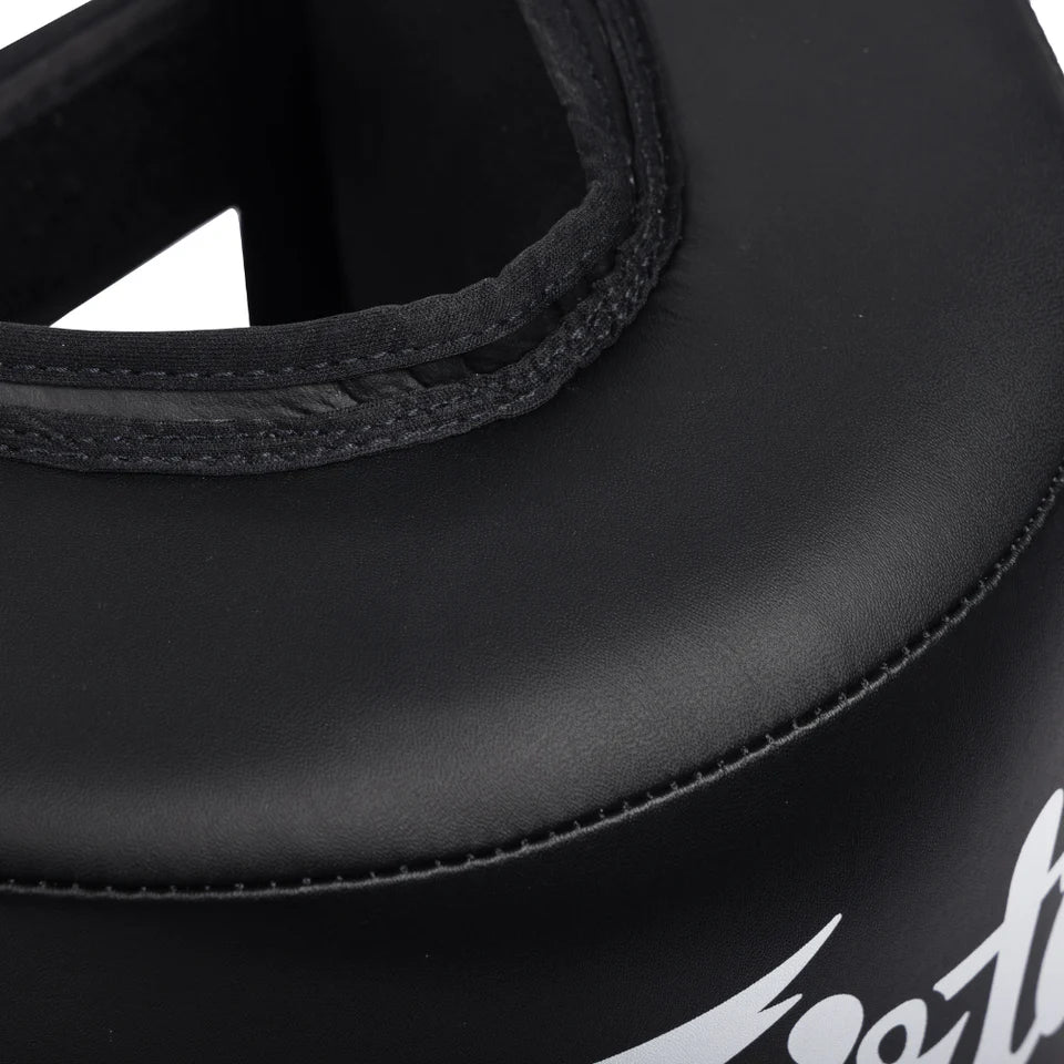 Closeup of black shin and calf protector with a Fairtex logo on a white background