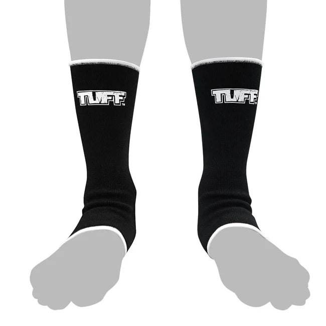 Black anklets with 'TUFF' logo worn by a person on a white background