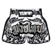Black and white Muay Thai shorts with 'TUFF' branding on a white background