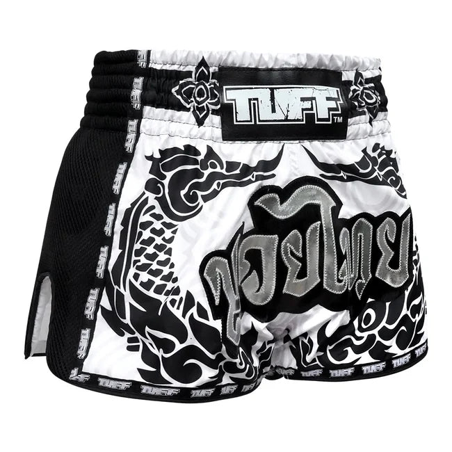 Black and white Muay Thai shorts with intricate designs on a white background