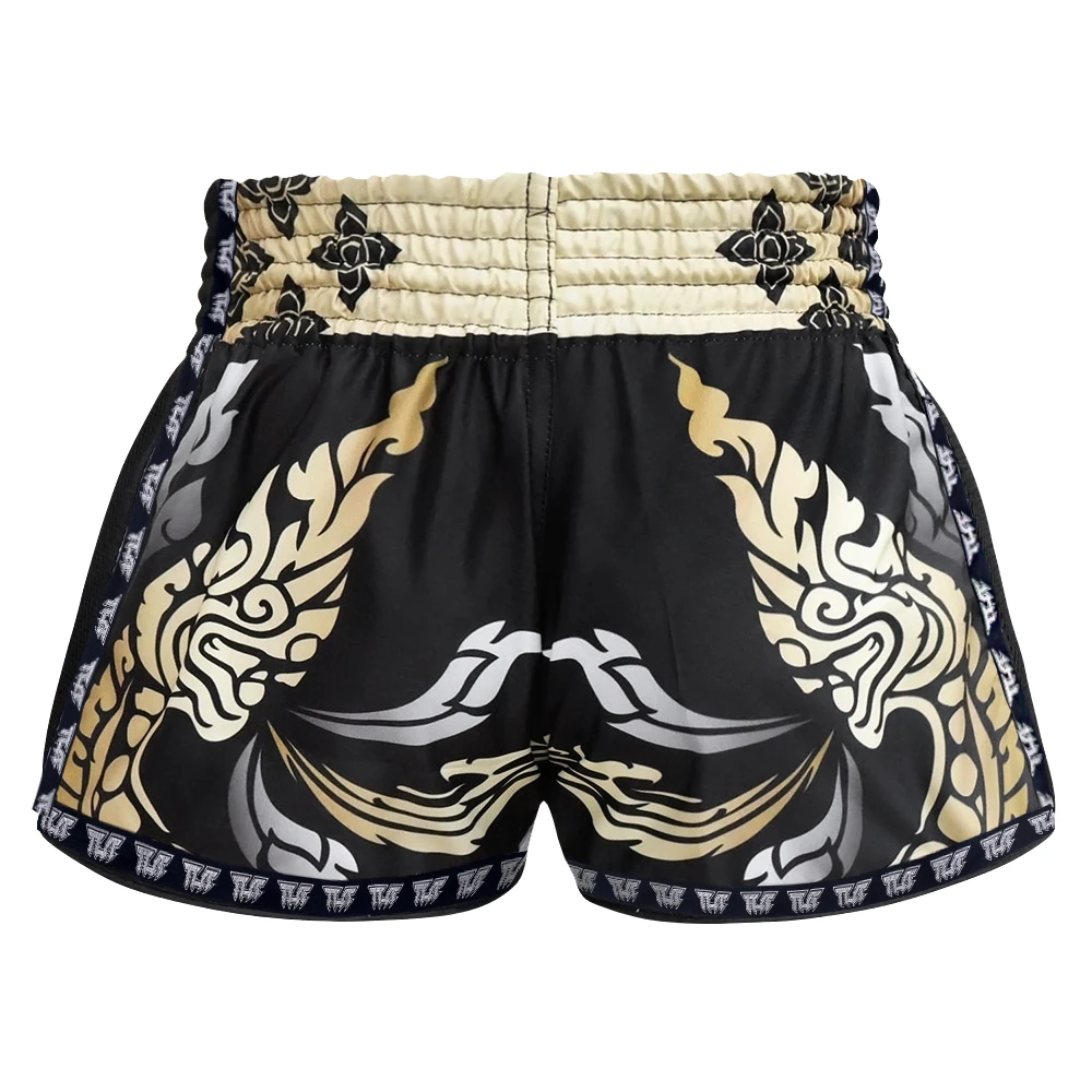Black Muay Thai shorts with gold and white tribal designs on a white background