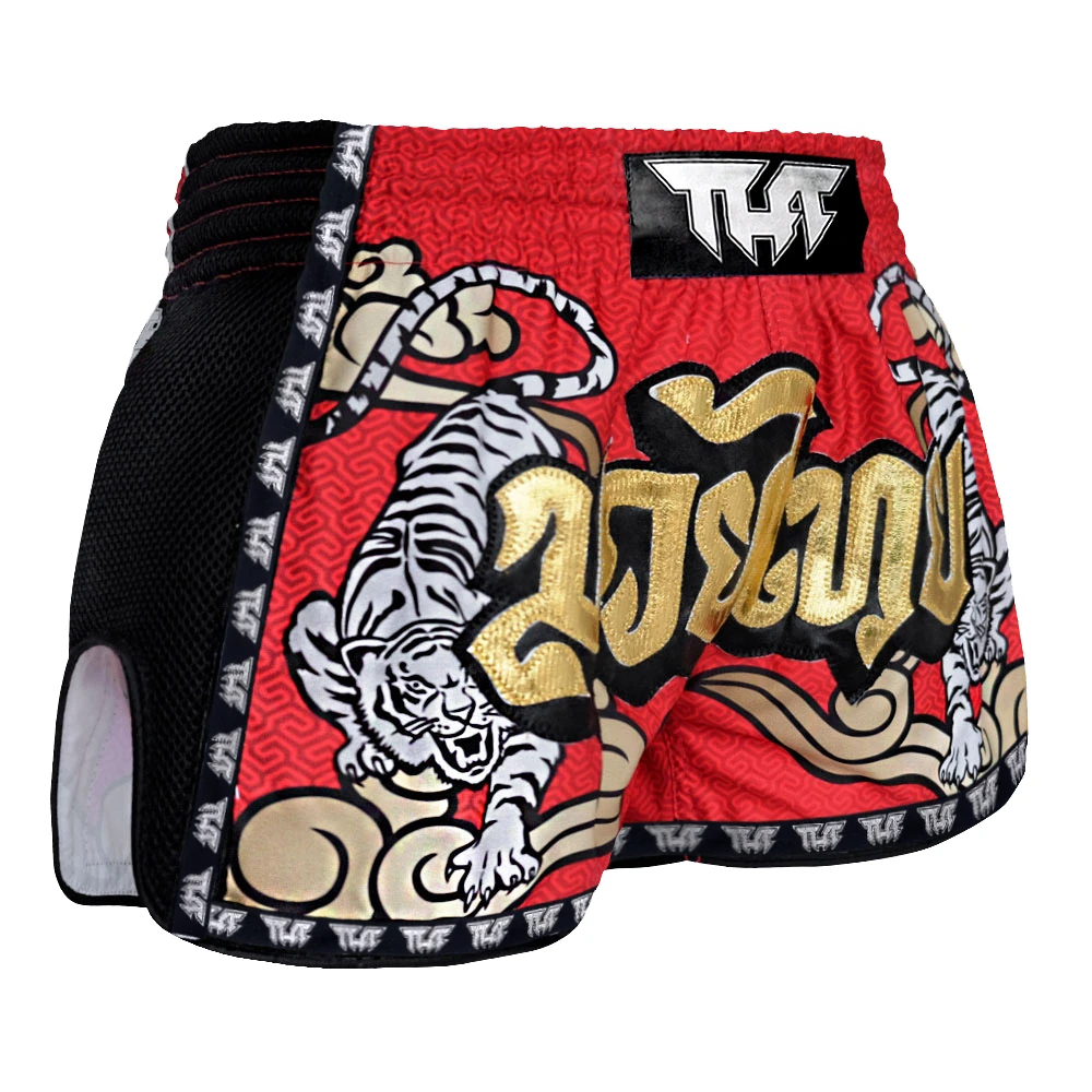 Red Muay Thai shorts with tiger design and visible brand logo on a white background