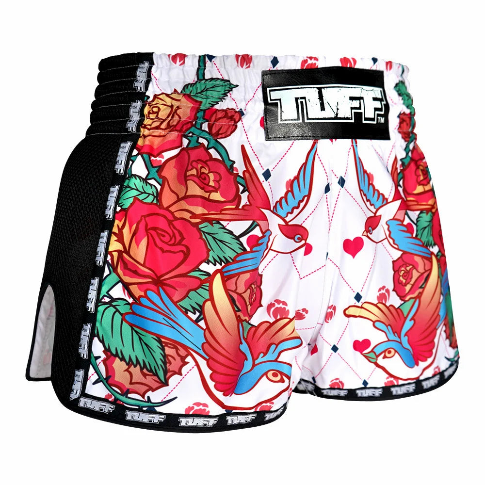Colorful tattoo-style Muay Thai shorts with floral and bird designs on a white background, featuring the brand 'TUFF'.