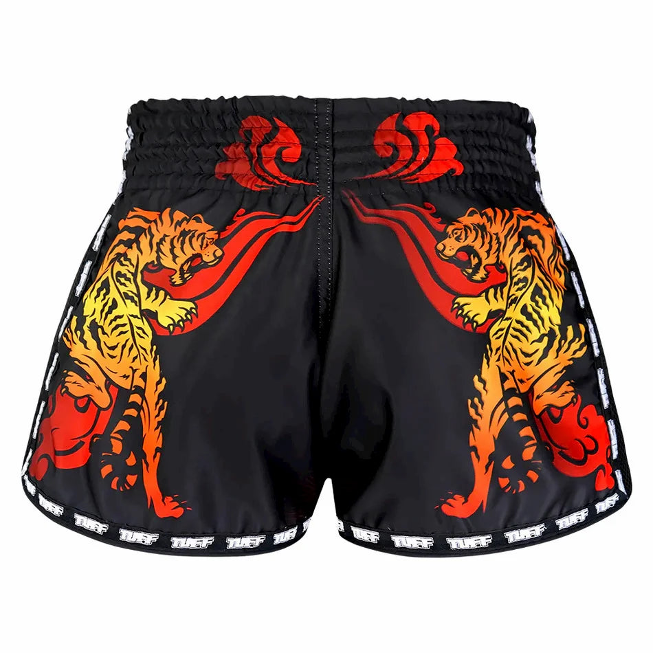 Black Muay Thai shorts with red and orange tiger designs on a white background