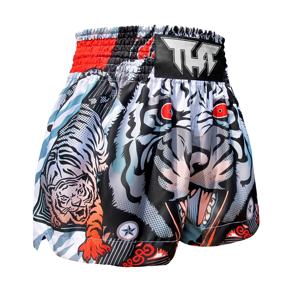 Muay Thai shorts with tiger design and brand logo on a white background