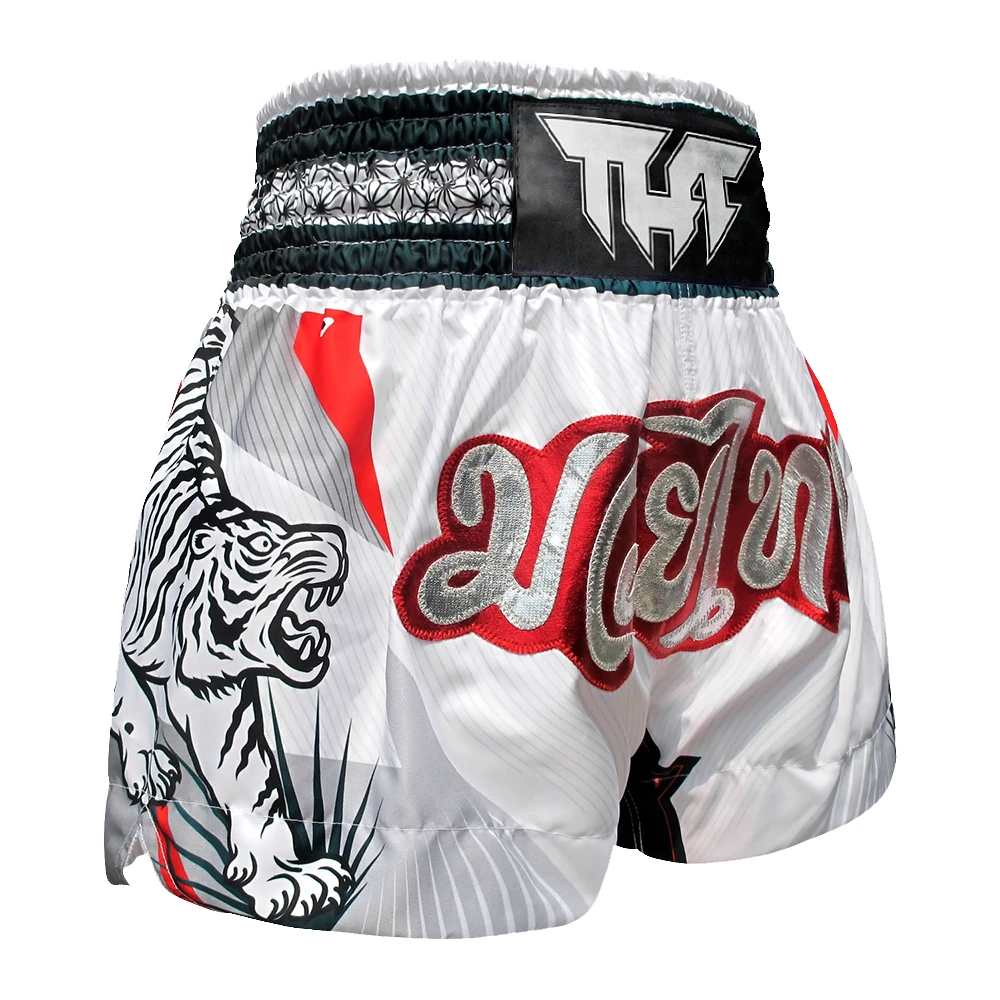 White Muay Thai shorts with a tiger design and red text on a white background