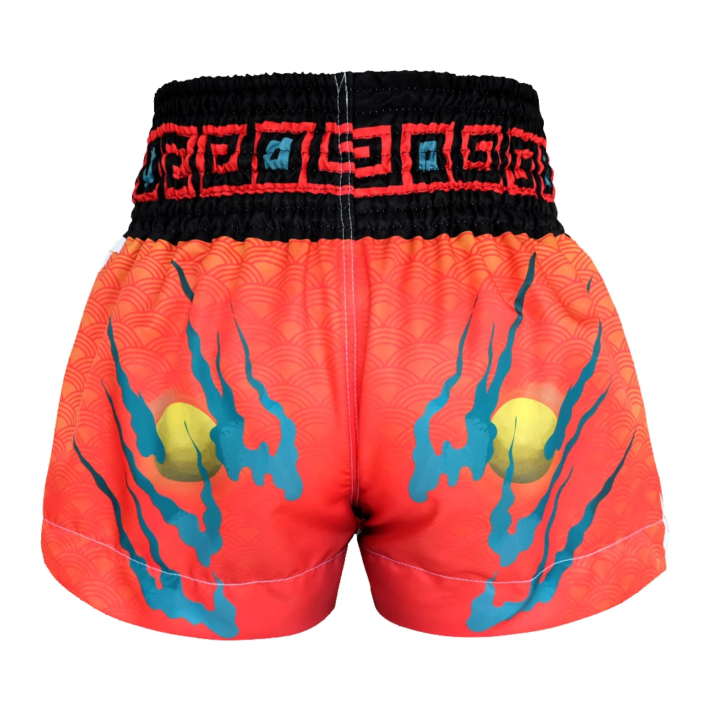 Red Muay Thai shorts with blue designs and a black waistband on a white background