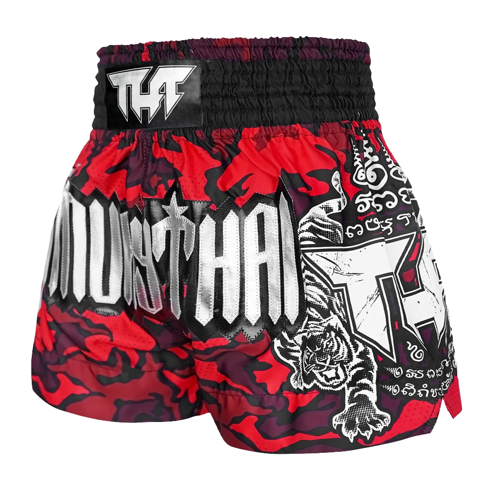 Red and black Muay Thai shorts with white text and graphics on a white background