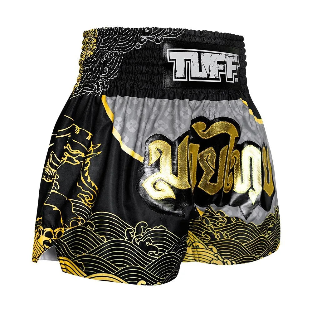 Black and gold Muay Thai shorts with 'TUFF' branding on a white background