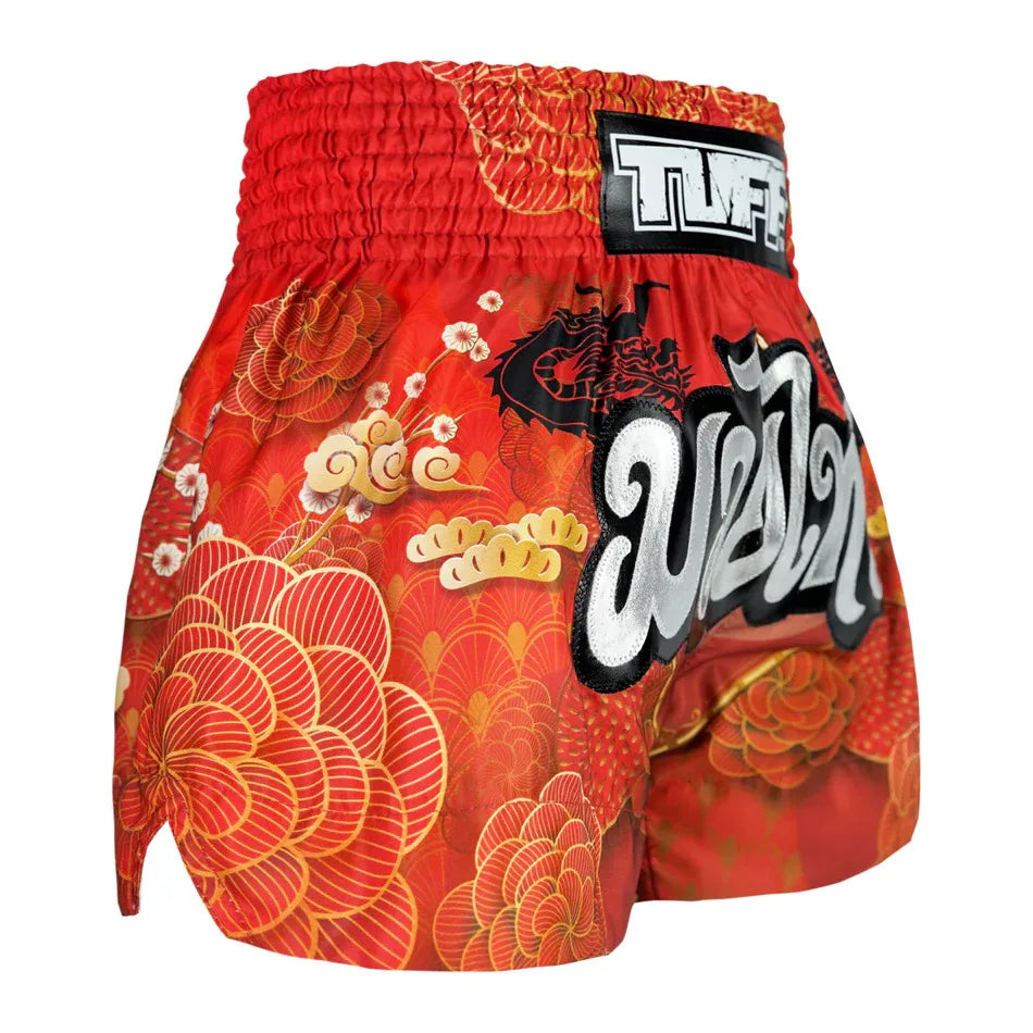 Red floral Muay Thai shorts with a prominent brand logo on a white background