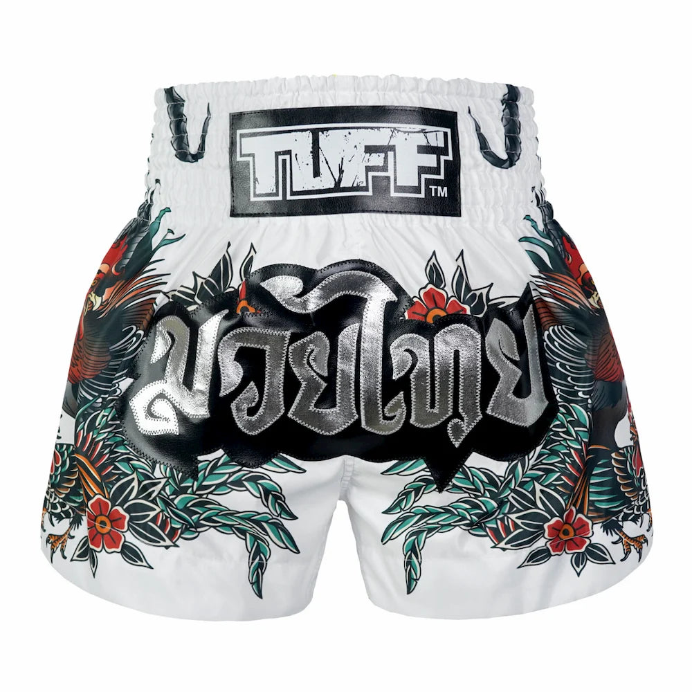 White Muay Thai shorts with colorful designs and 'TUFF' branding on a white background