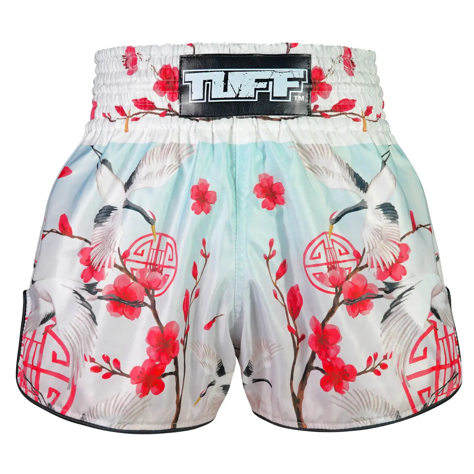Floral and crane-patterned Muay Thai shorts with a visible brand label on a white background