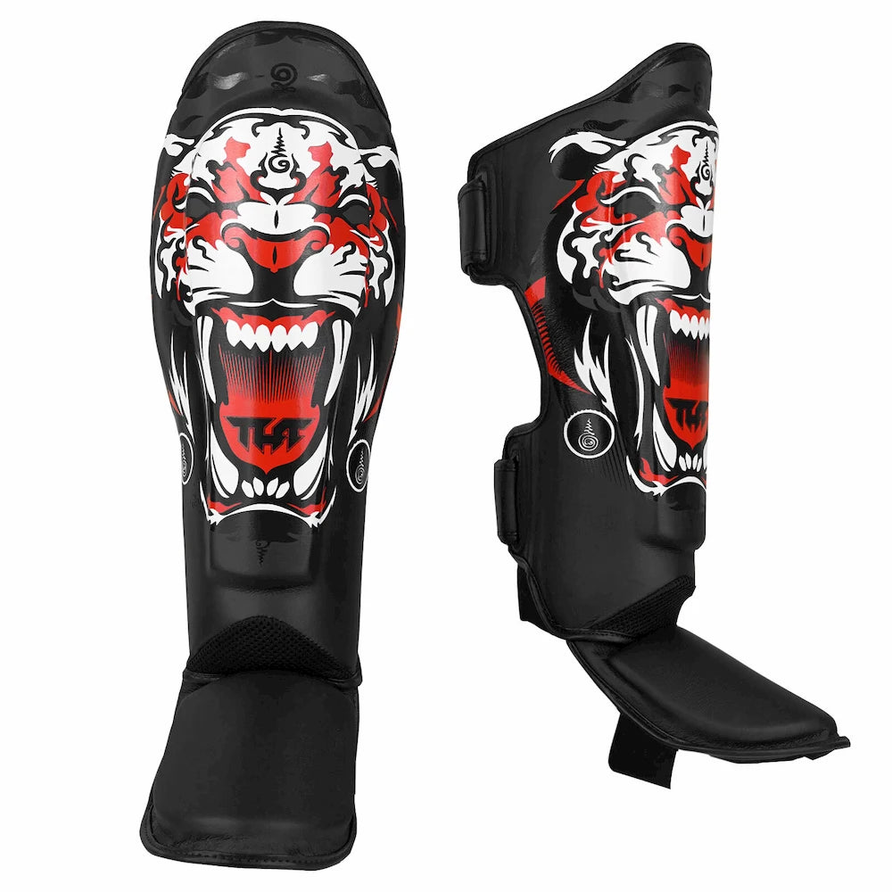 Black shin guards with a tiger design on a white background